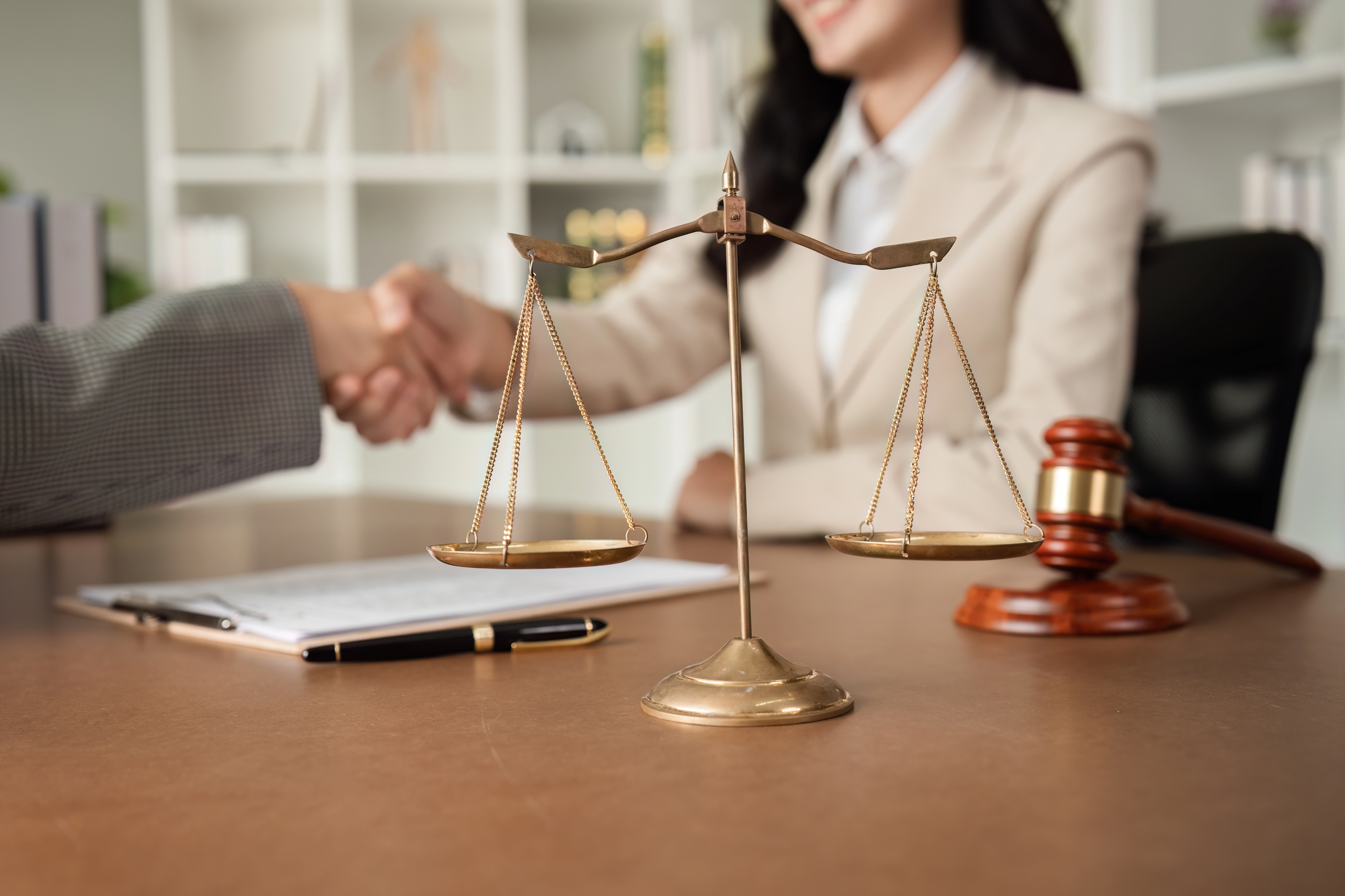 A lawyer and a client shake hands in a professional office setting, conveying trust and agreement for a free legal consultation